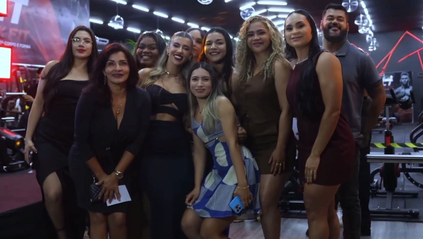 Foto de um professor de educação física orientando um aluno na academia.